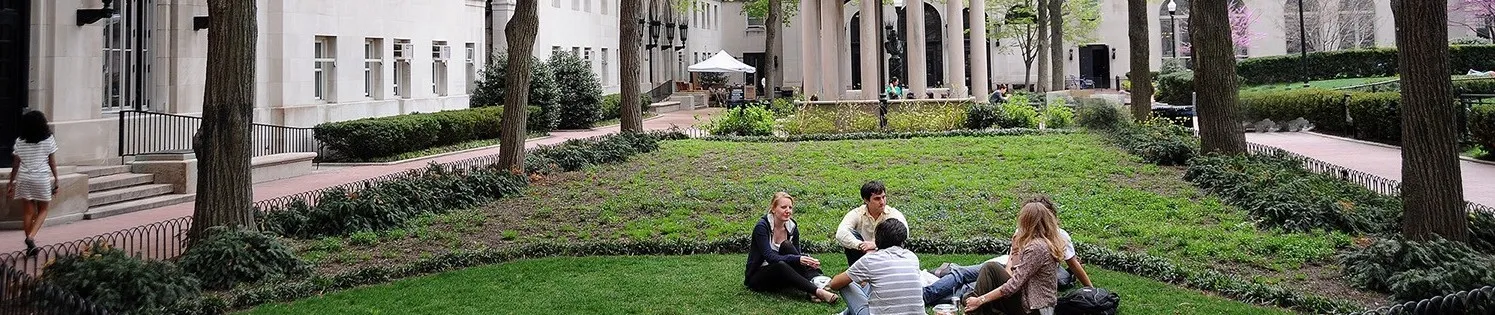 Students sitting on the grass on campus