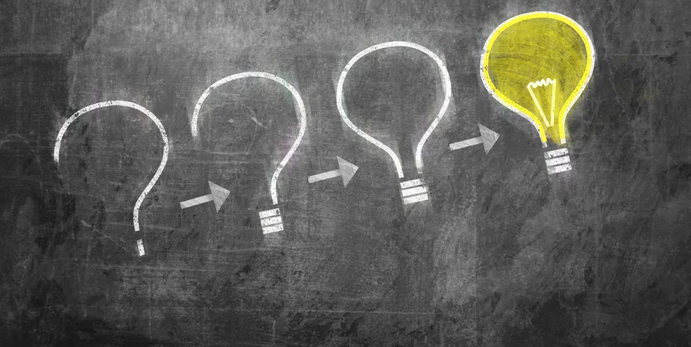 drawing on chalkboard of a question mark becoming an idea