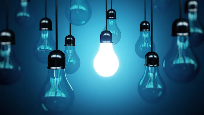 Photo of hanging lightbulbs, with only one lit