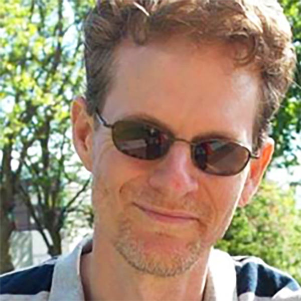 Photo of Bryon Vaughn (man with curly blond hair, wearing sunglasses)